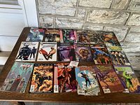 Full view of 18 assorted vintage comic books laid out on table showing cover art and titles