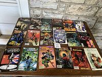Top view of all 18 comic books laid out in a grid showing various titles and vibrant cover art including Conan, Batman, and others.