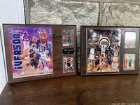 Two framed Allen Iverson plaques on wooden surface against stone background, showing front display details.
