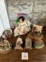 Photo showing 7 Indigenous American collectibles including Prairie Lullaby doll, tipis, figurines and heritage scenes
