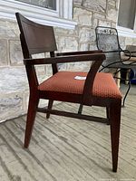 Side view of the vintage chair showing the wooden frame, angled legs, and fabric seat upholstery.