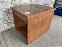 Front angle view showing top surface and side panel with open shelf below.