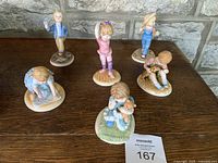 Array of six Lenox porcelain figurines on wooden surface, representing days of the week theme