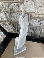 Front angled side view of Lladro porcelain figurine of a doctor wearing glasses and stethoscope.