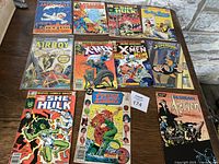 Full lot of 11 vintage comics laid out on table showing titles and cover art