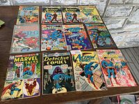 Full lot of 12 vintage Marvel and DC comic books laid out showing covers