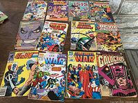 Photo showing a collection of 12 vintage comics laid out on a dark surface, including classic Marvel and other superhero titles from 1970s and 1980s