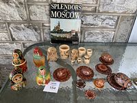 Front view of all nesting dolls, wooden balls, plates, and book