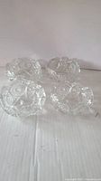 Four clear cut crystal dishes with star and geometric cut patterns, displayed from top angle.