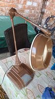 Whole lamp showing brown finish, adjustable arm, magnifying glass shade, and base with worn paint.