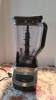 Full front view of Ninja Professional Blender NJ600 showing clear container with handle and control panel on base