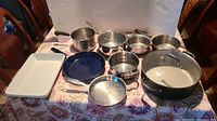 Full set of 11 pots and bakeware arranged on table showing variety and sizes.