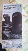 Box front showing Sharper Image Portable Air Purifier, black cylindrical design, True HEPA filter, USB powered.