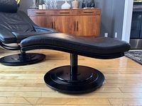 Side profile showing contoured leather cushion and disc base