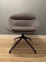 Front view of grey upholstered swivel chair with black aluminum base