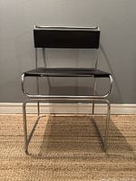 Front view of entire chair showing chrome frame and leather seat