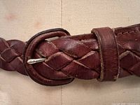 Close-up of the braided leather belt buckle and leather loop, showing details and condition.