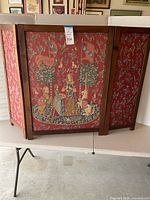 Front view of 3-panel hinged fireplace screen showing the detailed needlework central panel with lady and unicorn scene