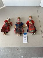 Full view of three Oriental opera dolls laying flat showing detailed costumes and faces.