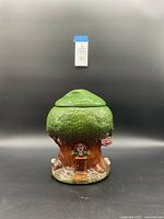 Front view of the ceramic Keebler cookie jar shaped like a tree with elf decoration and lid on top