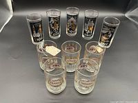 Ten vintage TWA Airlines drinking glasses organized in two rows showing all with travel destinations and TWA branding.