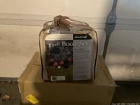 Photo of the Rivoli Bocce Set in beige carrying bag resting on boxes in a garage.