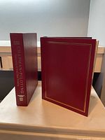 Front open photo of the book and the slipcase both in burgundy with gold embossing.