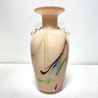 Front view showing beige vase with colorful swirls and handles.