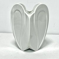 Front view of white porcelain planter showing the petal-shaped embossed design on two sides