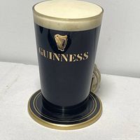 Official Guinness bar light shaped like a pint glass with white foam top and gold logo on black body.