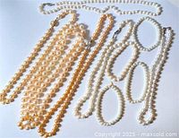Clear overhead photo of all necklaces and bracelets showing different shades of faux pearls, mostly white and champagne color, with varied bead sizes and clasp types.