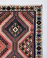 Close-up of border and central medallion showing geometric pattern and color palette