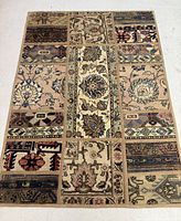 Full view of the Persian Tabriz patchwork rug showing its rectangular panel design in beige, blue, cream, and brown.