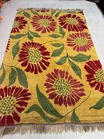 Overhead view of full rug laid flat showing overall sunflower design and fringe