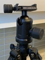 Close-up of the ball head with adjustment knobs and quick release plate showing the brand Cameron.