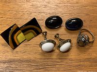 All four pairs of earrings and Avon ring displayed on wood surface showing detail and color variety.