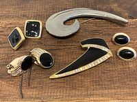 Lot of vintage Monét jewelry with black and gold tone finish, crystals, and silver tone pin.