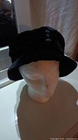 Side view of black Betmar New York women's hat displayed on mannequin head