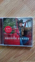 Front cover of George Strait 'Fresh Cut Christmas' CD showing the artist and price sticker $7.95 on jewel case.