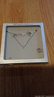 Photo of Kenneth Cole necklace, earrings, and ring set new in original packaging.
