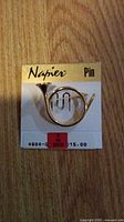 Photo of gold-tone trumpet pin attached to original Napier labeled card, with price tags visible