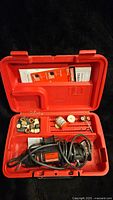 Photo of Craftsman rotary tool kit with tool, accessories, and instruction manual inside red carrying case.