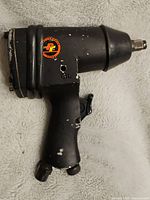 Front view of the Performance Tool PT impact air drill showing the drill head, trigger, and logo sticker.