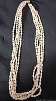 Full view of the multi-strand pearl necklace with gold beads.