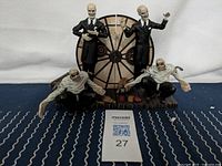 Full set of two Gentlemen and two henchmen figures on mechanical stand with accessories in front