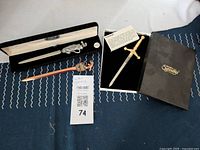 Set of three mail openers displayed together: pewter golf bag style, bronze Florida style, and boxed Scottish sword opener.