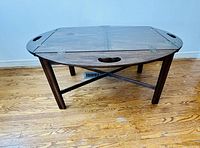 Wooden butler's coffee table with rectangular top, removable tray in center, visible wear on surface and legs