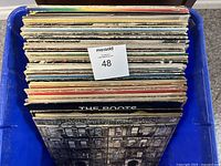 Top down view of 42 vinyl LP records stacked vertically showing album edges with wear