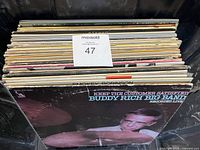 View of 31 vinyl LP records stacked showing front covers, including Buddy Rich Big Band album visible