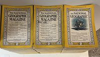 Stack of National Geographic magazines with vintage yellow borders, showing primarily cover pages dated through the 1950s.